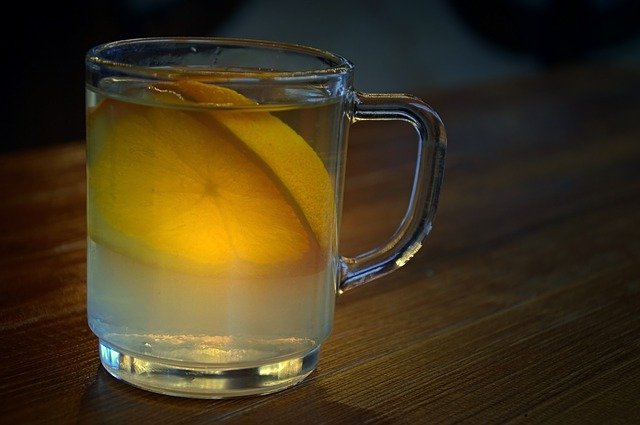 Glas of hot spiced wine with a piece of lemon in it on a table