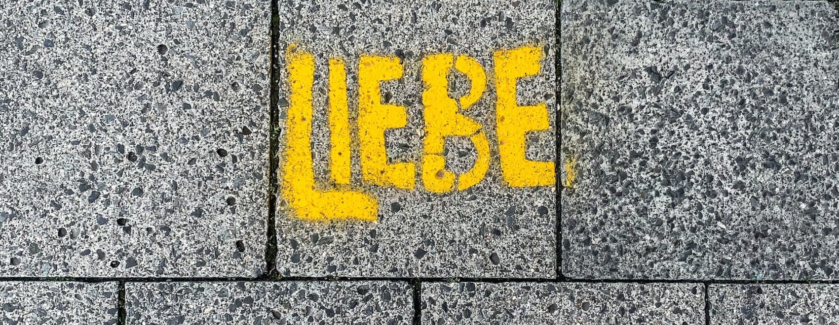 Gelbes Graffiti auf dem Boden mit Schriftzug "Liebe"