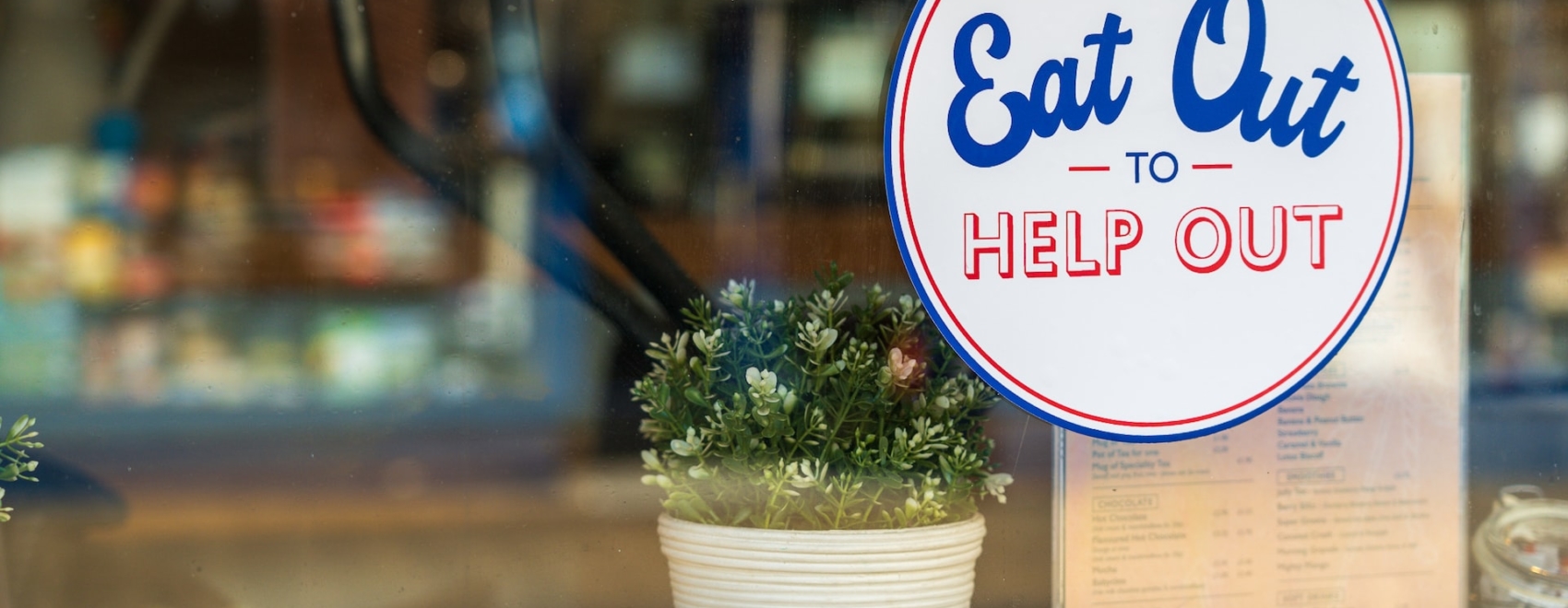 Sticker "Eat out to help out" an Fensterscheibe