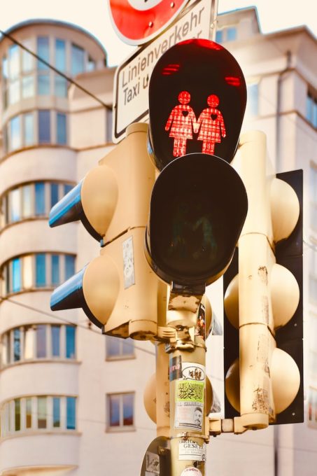 Red traffic light in Munich with two females holding hands